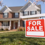 A "For Sale" sign marks a charming two-story brick home with blooming cherry blossoms and a well-kept lawn.